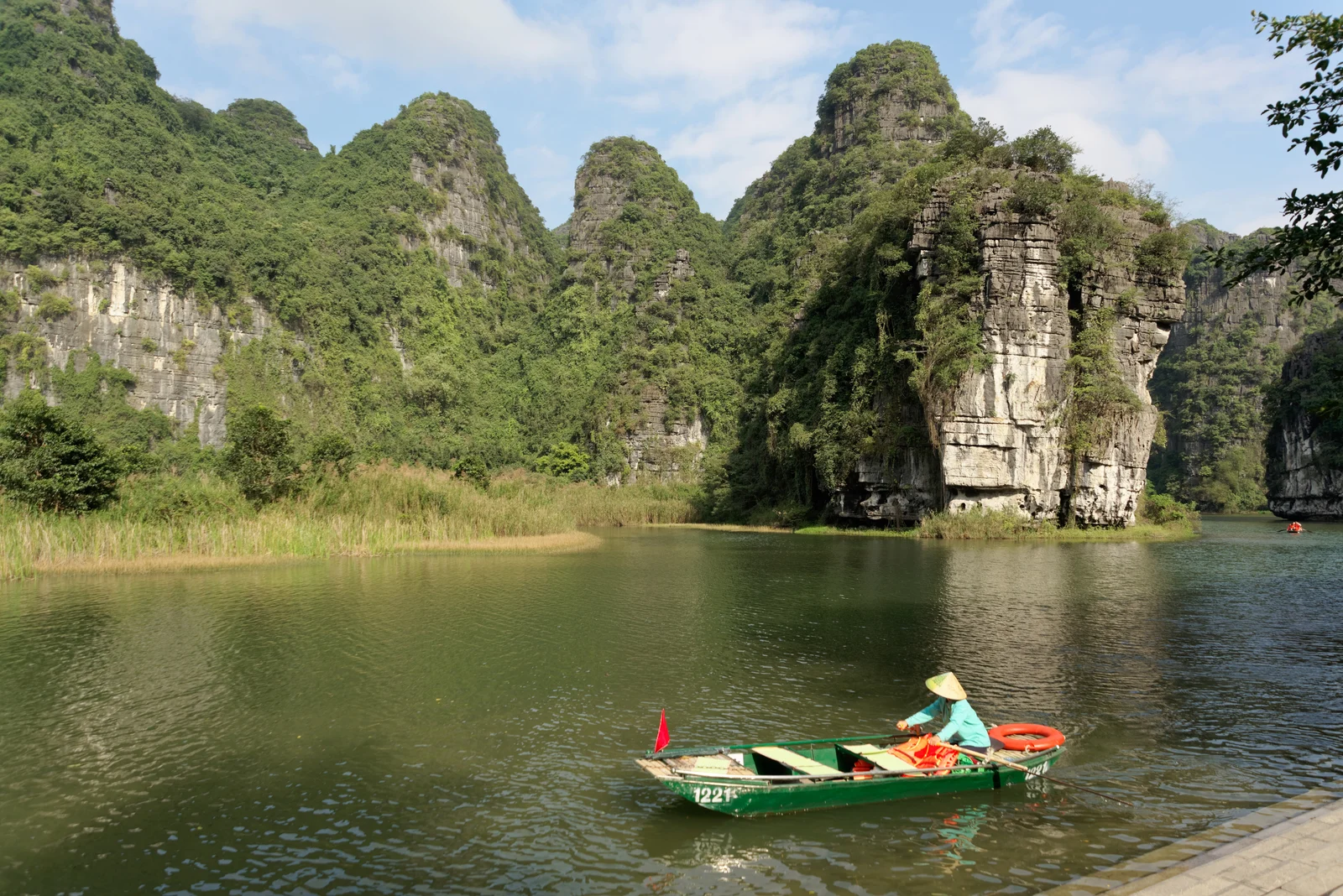 Thuyền tham quan giữa cảnh quan núi đá vôi Tràng An, Ninh Bình.