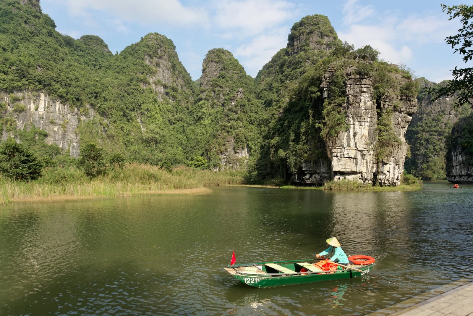 Thuyền tham quan giữa cảnh quan núi đá vôi Tràng An, Ninh Bình.